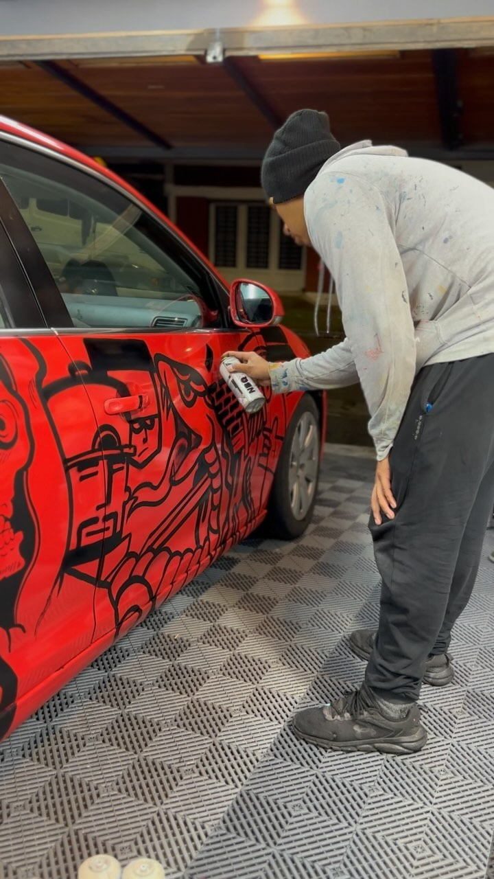 Wanqueo pintando un auto con aerosol